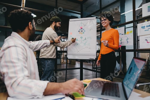 Preview: Group of cheerful colleagues discussing project in office