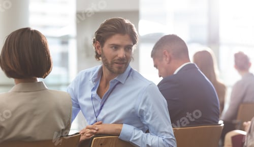 Preview: Businessman interacting with his colleague during seminar in office building
