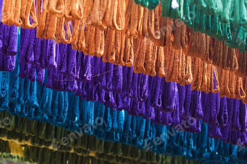 Preview: Close up on colored cotton threads outside of a small factory in Asia.