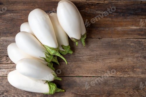 Preview: Harvest white eggplants on a wooden background with place for text. Eggplant vegetable on the table