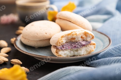 Preview: Meringues cakes with cup of coffee on a black concrete background. Side view, selective focus.