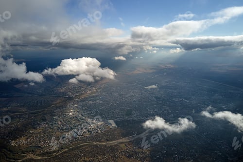 Preview: Aerial view from airplane window at high altitude of distant city