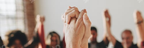 Preview: Group of diverse people holding hands up in the air