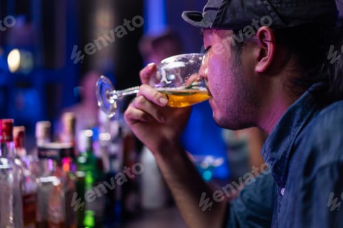 Preview: Asian depression man feeling heart broken and drinking beer in a bar.