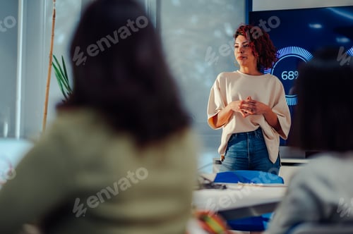 Preview: Hispanic latino female team leader using chart on a big digital screen