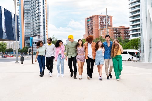 Preview: Happy playful multiethnic group of young friends bonding outdoors