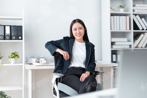 Preview: Young Asian businesswoman sitting relaxed in office chair