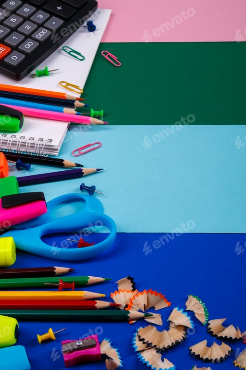 Visualização: Papelaria escolar ou de escritório em fundo colorido.