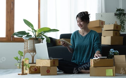 Preview: Asian women write note of orders of goods with a smiling face in concept of sme, e-commerce business