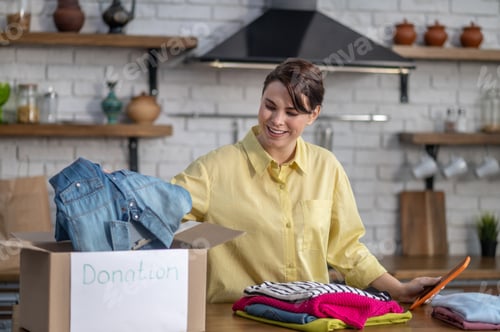 Preview: Joyful vlogger packing clothes for donation before the camera