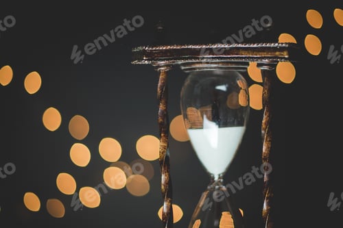 Preview: Closeup shot of a sand glass with blurred lights in the background