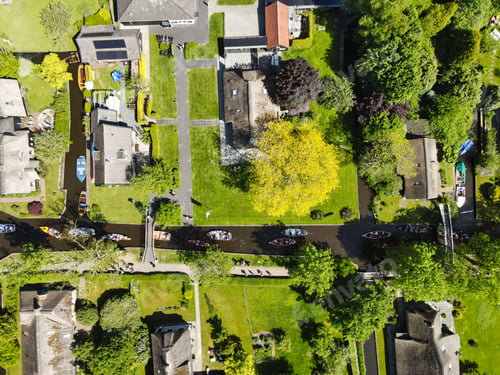 Preview: Aerial top view of Giethoorn village with green trees,houses and boats in a river