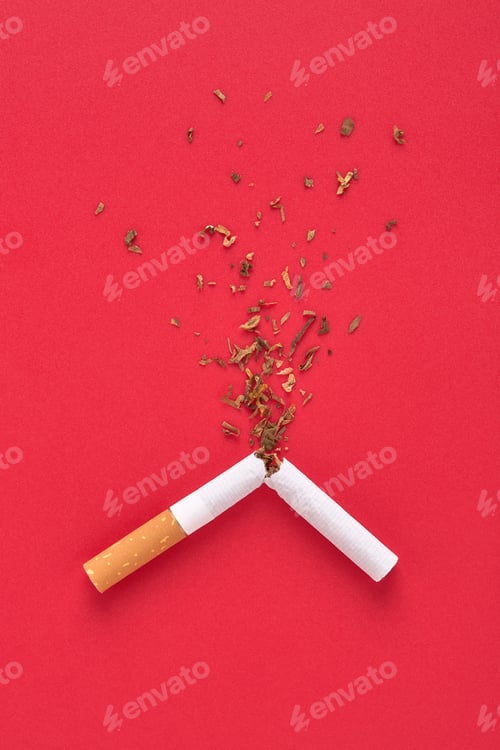Visualização: Um cigarro quebrado com respingos de tabaco em fundo vermelho