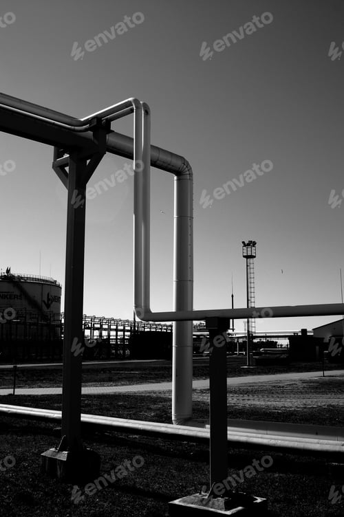 Preview: Grayscale vertical shot of gas pipelines in the industrial zone