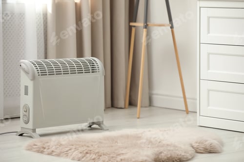 Preview: Modern electric heater on floor at home