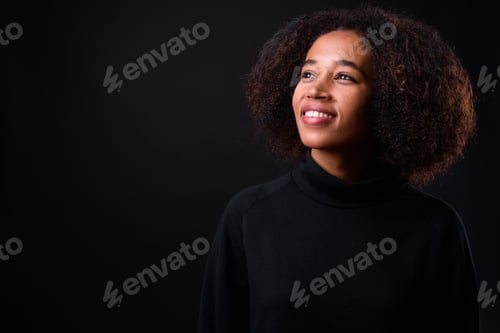 Preview: Young beautiful African woman with Afro hair against black background