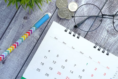 Preview: detail shot of a calendar and pen on wooden background