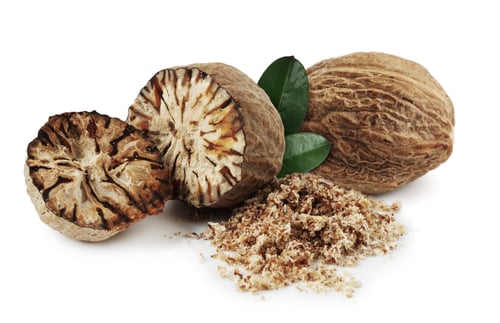 Preview: Nutmeg seeds with green leaves on white background. Aromatic spice
