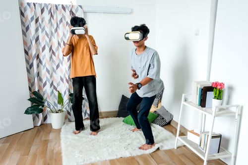 Preview: Young Asian Man Standing, Wearing VR Headset And Actively Engaged In Virtual Reality Experience