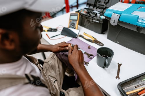 Preview: Technician repairs tools in workshop while sitting at desk with various instruments and materials