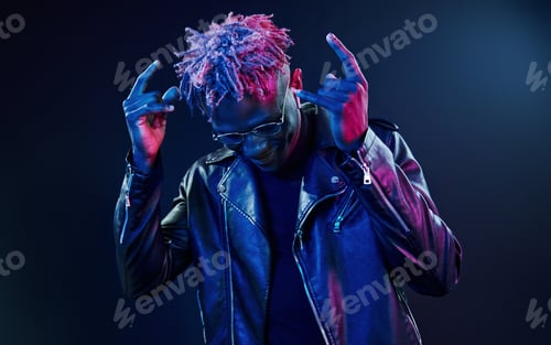 Preview: Having fun. Futuristic neon lighting. Young african american man in the studio