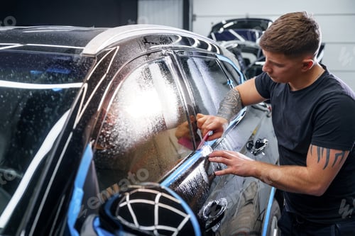 Preview: Sticker of a protective film on the headlight of a car in a car detailing studio