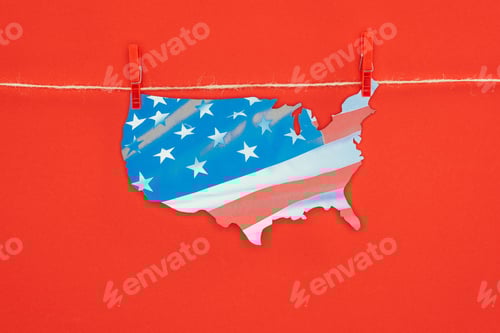 Preview: top view of piece of map with american flag hanging on rope isolated on red, presidents day concept