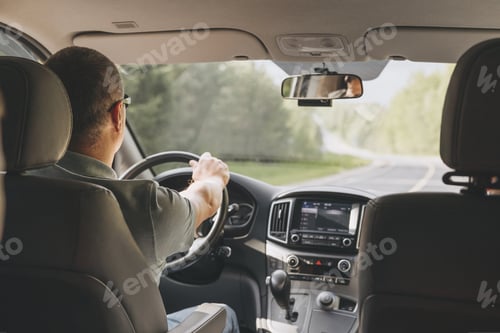 Preview: Young man holding steering wheel while driving car. Road trip adventure