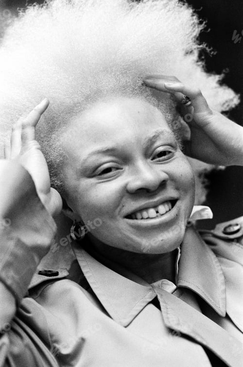 Preview: Funny analog image of happy albino woman smiling and holding her hair outdoors.