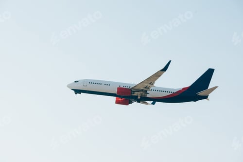 Preview: Low angle view of commercial airplane taking off in clear sky