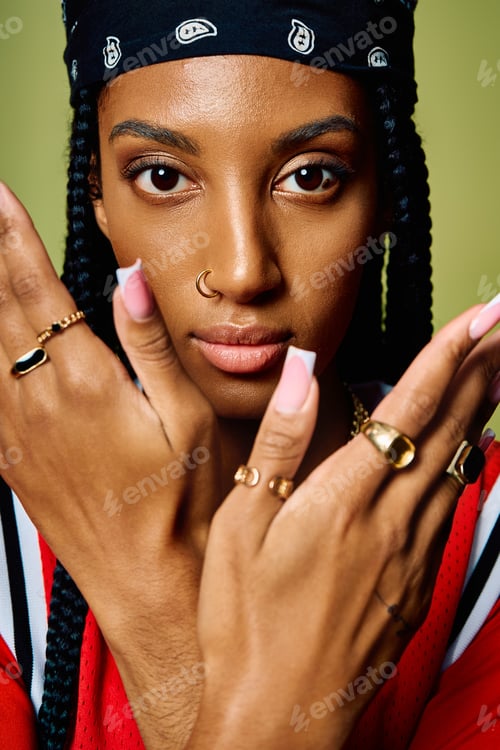 Preview: Woman with beautiful braids elegantly presents her hands adorned with unique rings and accessories.