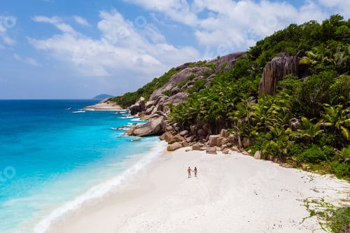 Preview: Couple men and woman walking at a tropical beach, Drone view from above Seychelles Cocos Island