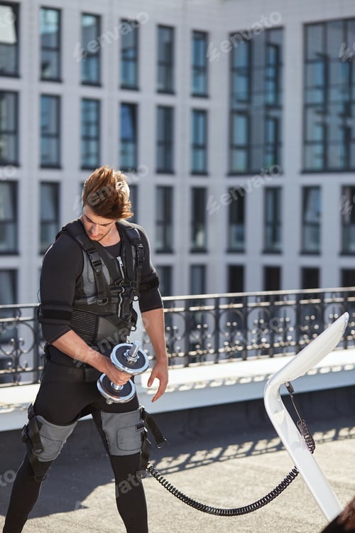 Preview: handsome ambitious bodyduilder in EMS suit