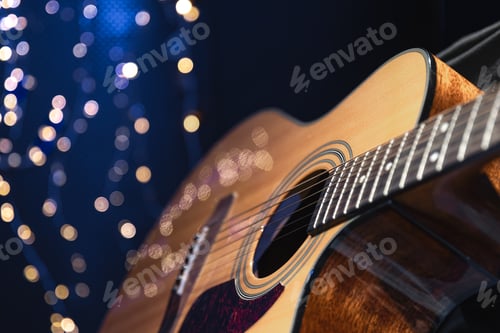 Preview: Close-up, acoustic guitar on a dark background with bokeh lights.