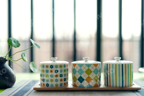 Three decorative containers on a bamboo serving tray