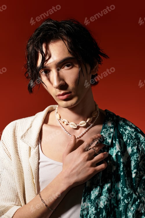 Preview: Young man showcases trendy summer fashion in vibrant studio setting
