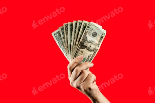 Preview: Hand holding a fan of US dollar bills against a vibrant red background.