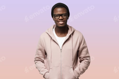 Preview: African male pictured isolated on purple background standing in calm relaxed posture in pink hoodie