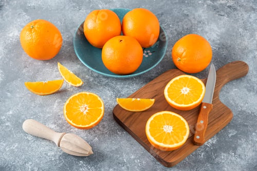 Preview: Sliced orange fruits with whole oranges on a wooden board