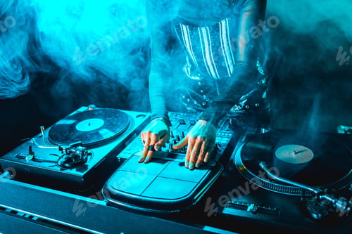 Preview: cropped view of dj woman using dj equipment in nightclub with smoke