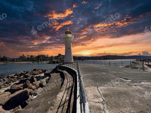 Preview: White lighthouse at the entrance to Wollongong harbor and a marina on the coast against the sunset