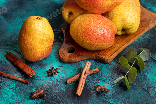 Preview: Pears on a dark background. Fresh, ripe fruits on a blue plate and in a box. Healthy eating.