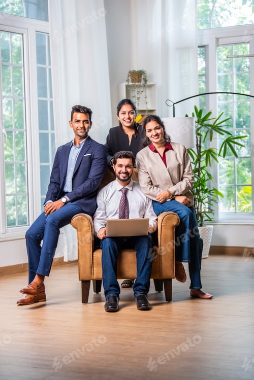 Preview: Group of young Indian asian business professionals using laptop in office