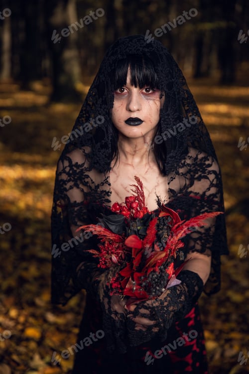 Preview: Pretty gothic caucasian female in a black dress posing in the park, vertical shot
