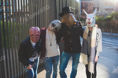 Preview: portrait of young people with funny masks standing in the street and looking camera