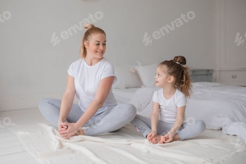 Preview: Woman and Girl Doing Yoga Together at Home