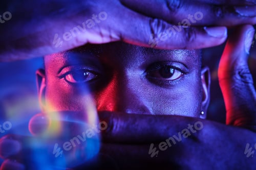 Preview: Crop black man looking at camera through camera hand gesture