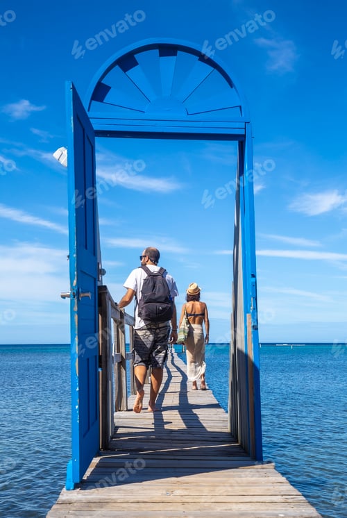 Preview: A couple at a blue door on the beach of Sandy Bay on Roatan Island. Honduras
