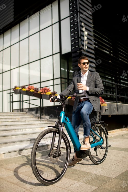 Preview: Young businessman on the ebike with takeaway coffee cup