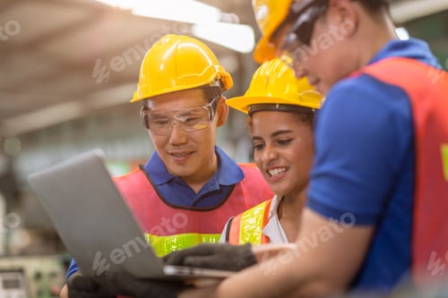 Preview: engineer women working with male team mix race work help together in heavy industry with laptop